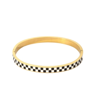 Golden hinged bangle featuring black and white checkered enamel design on white background