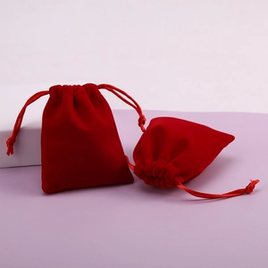 Detail view showing the soft texture and drawstring of two red velvet jewelry gift bags