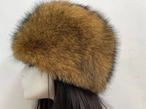 Side view of a thick brown faux fox fur hat on a mannequin head for winter warmth
