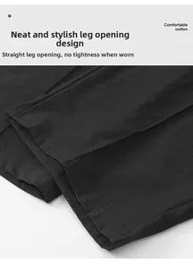 Detail of straight leg hem with double-stitch reinforcement on black cotton trousers