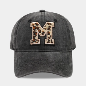 Close-up of washed cotton baseball cap featuring large leopard print M embroidery