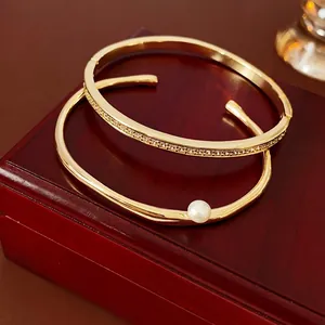 Minimalist gold geometric bracelet set with pearl and pavé crystals on a jewelry box