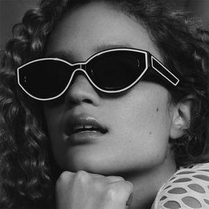 Lunettes de soleil œil de chat chic avec monture noire et ligne blanche sur modèle