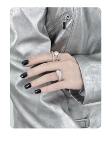 Macro view of double-layered twisted silver rings featuring a baroque pearl setting