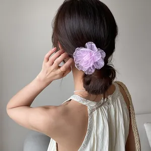 Détail d'un chouchou rose en organza violet montrant des pétales délicats multicouches