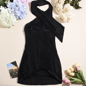 Detail of black halter mini dress with animal texture fabric among flowers
