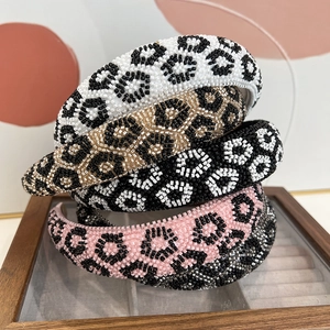 Close-up of handmade leopard print headbands with intricate beaded details in three colors