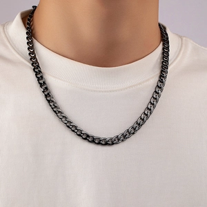 Close-up of a black metal Cuban link necklace worn by a model in a punk hip-hop style