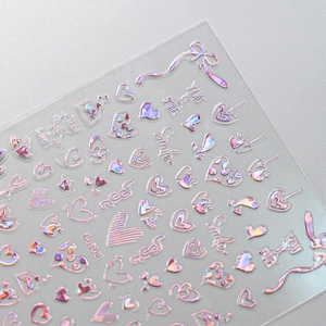 Macro view of holographic pink heart and bow nail stickers for Valentine manicures
