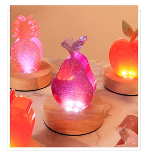 Macro view of pear-shaped glitter resin lamp glowing on a warm wooden light base