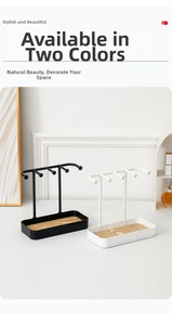 Close-up of modern metal jewelry display stand with four hooks and wood base tray