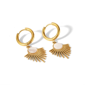 Detail of golden sunburst drop earrings with white shell inlay and round hoop clasp