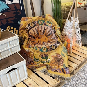 Detail of bohemian sun pattern woven blanket with decorative fringes in camping setting