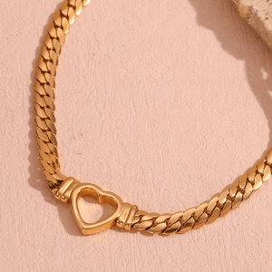 Detailed close-up of 18K gold-plated hollow heart pendant on a chunky flat link chain