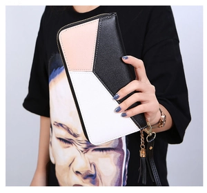 Detail of pink, white, and black geometric color block women's wallet with tassel zipper