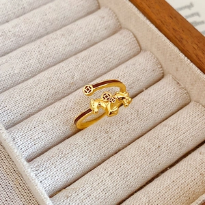 Macro shot of gold-plated horse ring with coin patterns in a velvet jewelry box