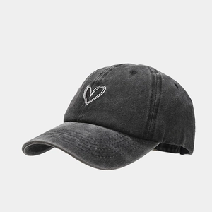 Detail der Herzbestickung auf einer gewaschenen dunkelgrauen Vintage-Baseballkappe
