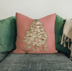 Pink Christmas pillow cover with festive hand-drawn tree and rocking horse on a sofa