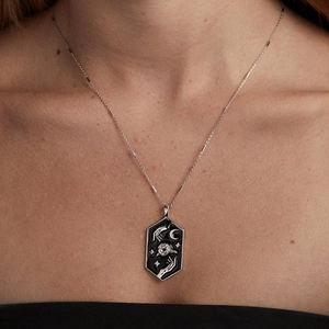 Nahaufnahme des sechseckigen Tarot-Anhängers mit Mond und Sternen an der Silberkette