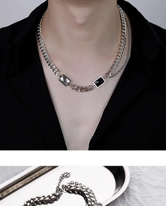 Detail of double-layered silver curb chain necklace with black and white crystal pendants
