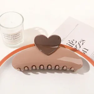 Detailed view of a sleek brown heart hair claw clip on a stylish decorative tray
