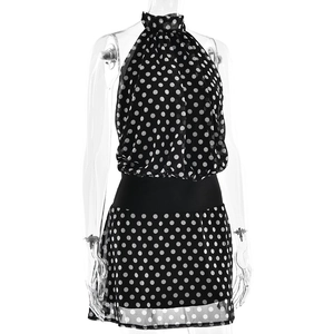 Détail du tissu à pois noirs et de la taille haute ajustée de la robe courte dos nu