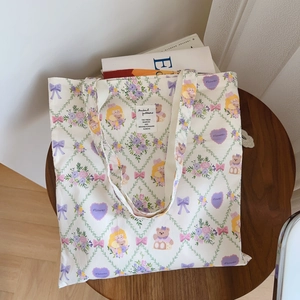 Détail du sac cabas en coton à imprimé floral français avec ours et nœud sur table en bois