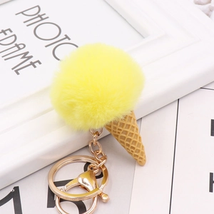 Detail of yellow faux fur pom pom ice cream keychain with golden lobster clasp and ring