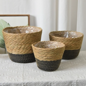Three sizes of natural seagrass baskets with black trim and waterproof plastic liners