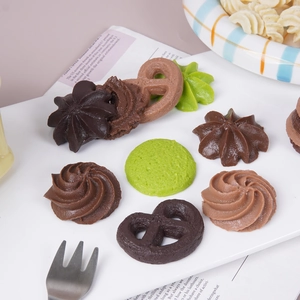 Assorted realistic faux cookie models in chocolate and matcha colors on a white plate