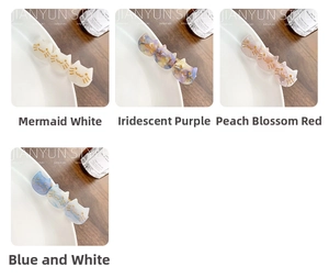 Detail view of cat-shaped acetate hair clips in pearl white, purple, pink and blue