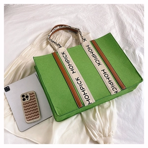 Detail view of a green felt tote bag with a branded wide shoulder strap and spacious design