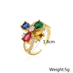 Detail of adjustable gold ring with multi-colored gemstones showing 1.8cm diameter