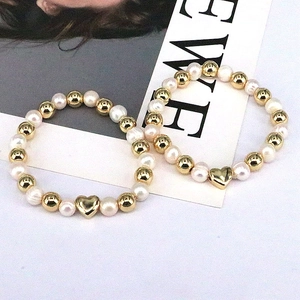 Elegant beaded bracelet with natural freshwater pearls and a gold heart charm pendant