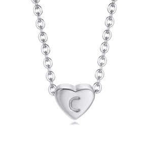 Macro shot of silver heart necklace pendant engraved with alphabet letter C on white background