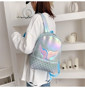 Detail showing the iridescent laser finish and mermaid tail embroidery on the blue backpack