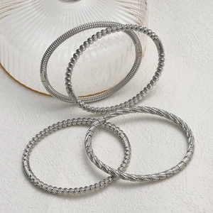 Silver stainless steel stacked bracelets featuring bead and twisted rope texture designs