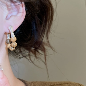 Gros plan de boucles d'oreilles vintage avec perles en bois naturel et fini argenté
