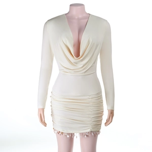 Détail de la robe crème avec décolleté en V profond, ourlet froncé et franges à paillettes
