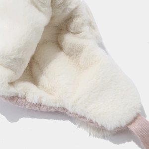 Detailed macro view of the soft white plush lining and pink knit texture on a winter hat