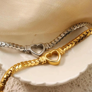 Detailed close-up of gold and silver cuban link necklaces with hollow heart pendants