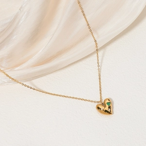 Gold heart pendant necklace with emerald green gemstone and sparkling white crystals