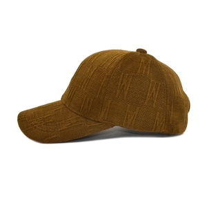 Detail of caramel brown knit baseball cap with 3D M-letter jacquard texture for autumn