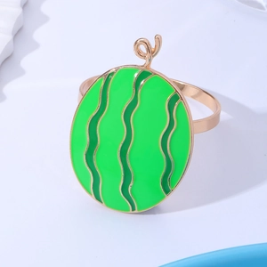 Detail of a watermelon slice napkin ring in green and gold finish on white background