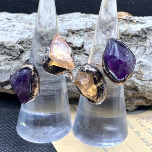 Macro detail of raw amethyst and amber crystals set in vintage bronze open rings
