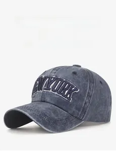 Detailed close-up of blue New York embroidery on washed grey vintage baseball cap