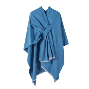 Detailed view of blue woven shawl featuring a unique knot design and fringed edges