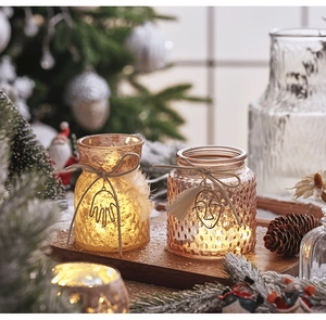 Detail of vintage glass Christmas candle holders with embossed textures and warm LED lights
