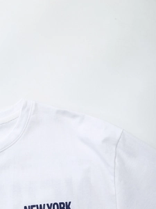 Detail of white T-shirt featuring black NEW YORK print on chest with neckline view