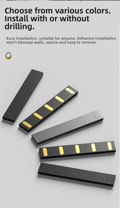 Close-up of minimalist black and grey folding wall hooks showing dual mounting methods